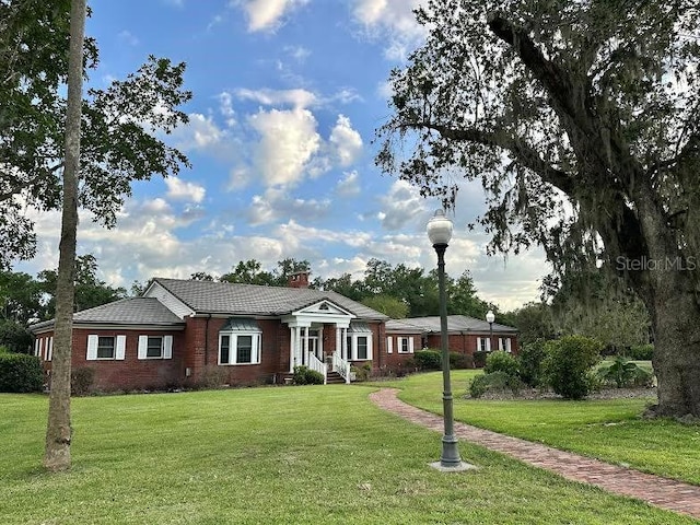 708 E Main St, Wauchula, FL 33873 - view of front of house featuring a front lawn, brick siding, and a chimney