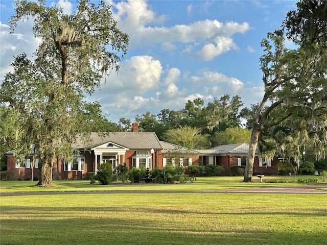 708 E Main St, Wauchula, FL 33873 - view of front of home with a chimney, a front yard, and brick siding