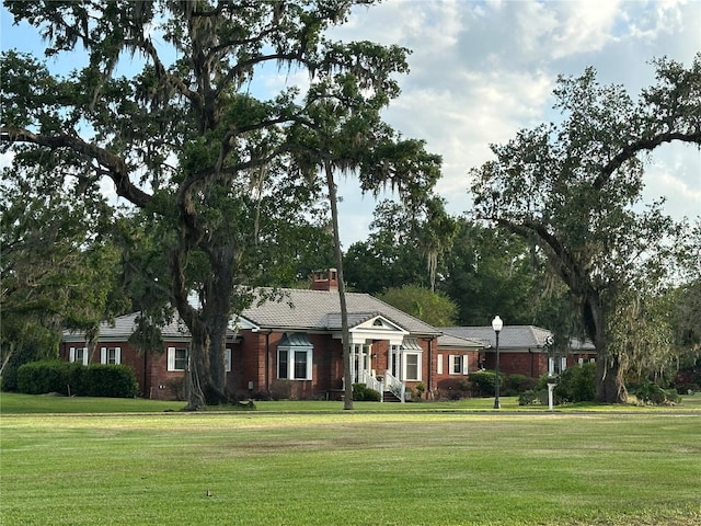 708 E Main St, Wauchula, FL 33873 - ranch-style home with a front lawn, brick siding, and a chimney