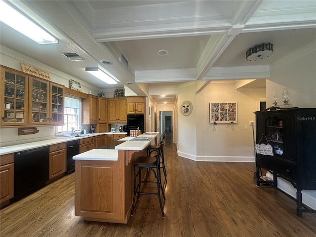 708 E Main St, Wauchula, FL 33873 - kitchen with glass insert cabinets, a center island, a breakfast bar, black appliances, and light countertops