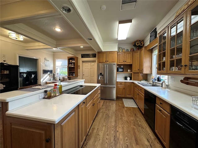 708 E Main St, Wauchula, FL 33873 - kitchen featuring a sink, black appliances, visible vents, light wood finished floors, and washing machine and dryer