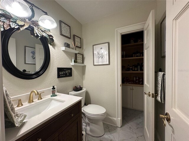 708 E Main St, Wauchula, FL 33873 - bathroom featuring toilet, marble finish floor, vanity, and a textured wall