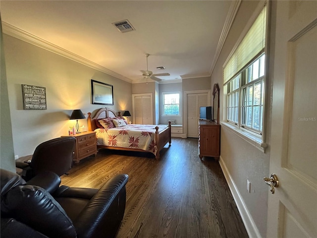 708 E Main St, Wauchula, FL 33873 - bedroom with crown molding, two closets, visible vents, baseboards, and dark wood-style floors