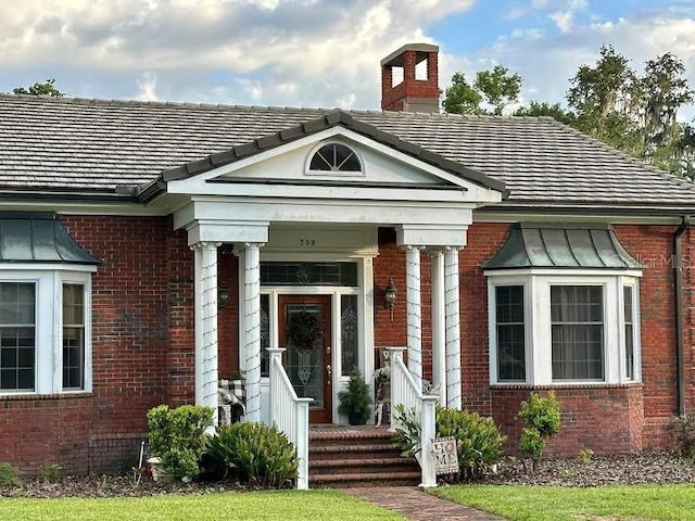 708 E Main St, Wauchula, FL 33873 - property entrance with a chimney and brick siding