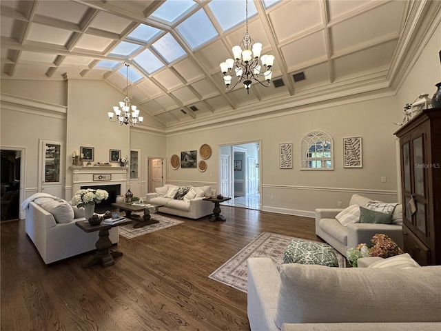 708 E Main St, Wauchula, FL 33873 - living area featuring an inviting chandelier, high vaulted ceiling, coffered ceiling, a fireplace, and dark wood-style flooring
