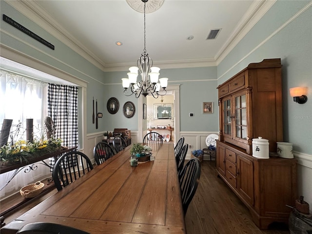 708 E Main St, Wauchula, FL 33873 - dining area with an inviting chandelier, visible vents, wainscoting, and dark wood-style floors