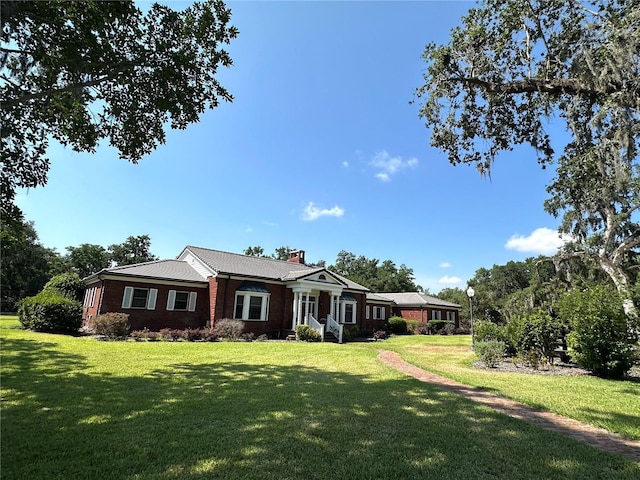 708 E Main St, Wauchula, FL 33873 - view of front of property featuring a chimney, a front yard, and brick siding