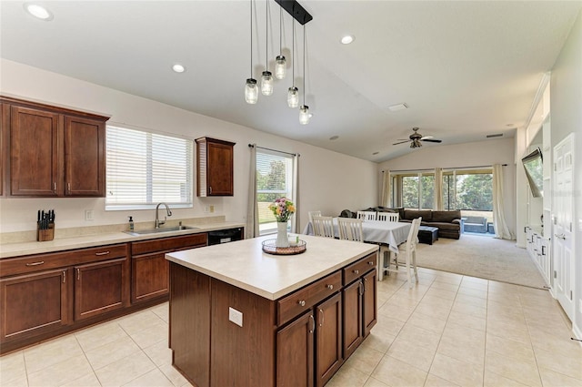 kitchen with vaulted ceiling, light tile patterned flooring, light countertops, and a sink