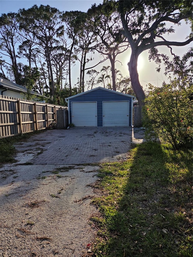 detached garage featuring fence