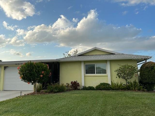 view of front of home with a garage, stucco siding, concrete driveway, a front yard, and roof with shingles