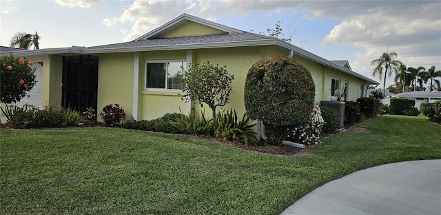 view of home's exterior with a lawn and stucco siding