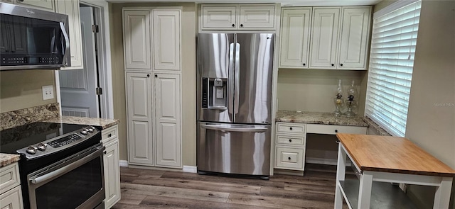 kitchen with wooden counters, stainless steel appliances, white cabinets, and dark wood-type flooring