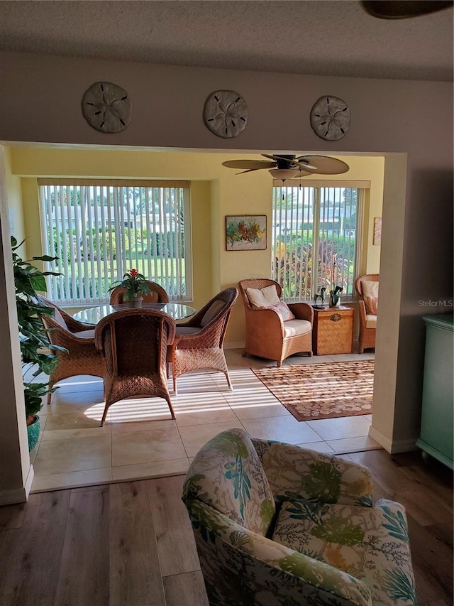 interior space featuring a wealth of natural light, ceiling fan, a textured ceiling, and wood finished floors