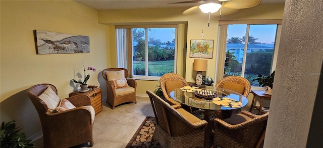 dining space featuring light tile patterned flooring, a ceiling fan, and plenty of natural light