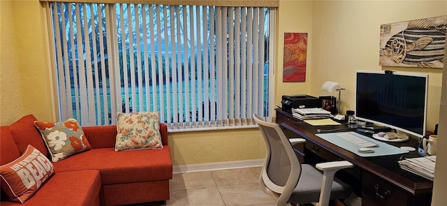 tiled office with baseboards and a textured wall