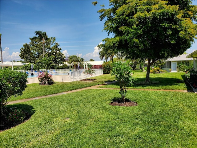 view of yard featuring fence and a community pool