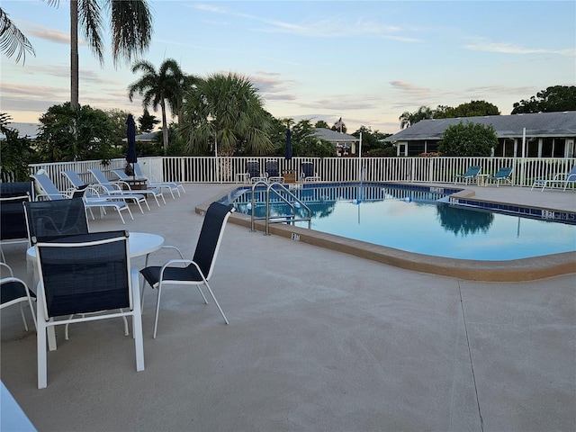 community pool featuring fence and a patio area