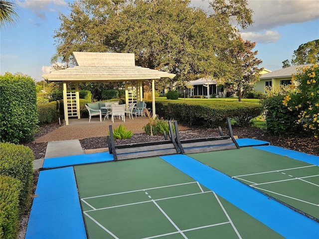 view of home's community with shuffleboard, a gazebo, and an outdoor living space