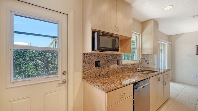 2259 Pueblo Ln Unit V38, Sarasota, FL 34231 - kitchen with stainless steel dishwasher, black microwave, a sink, light stone counters, and backsplash