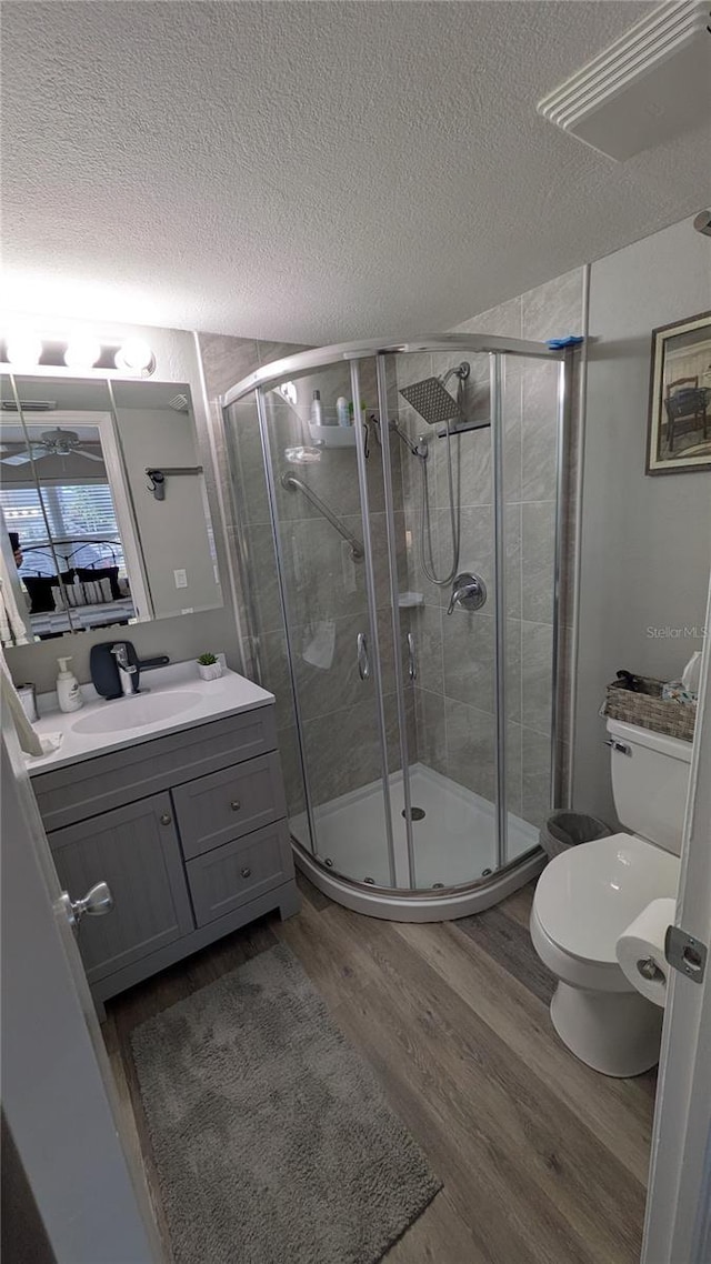 4158 Tamiami Trl Unit V1, Port Charlotte, FL 33952 - bathroom with vanity, toilet, a stall shower, a textured ceiling, and wood finished floors