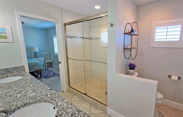 ensuite bathroom with a healthy amount of sunlight, a stall shower, and a sink