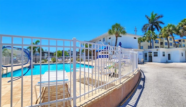 community pool with a patio and fence