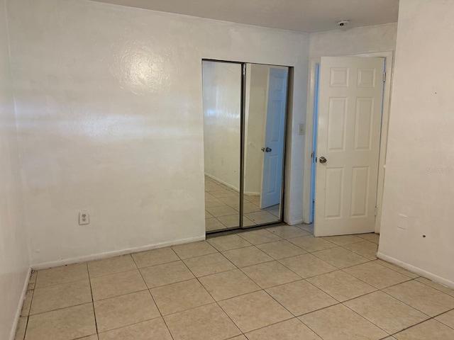 5014 22nd St W, Bradenton, FL 34207 - unfurnished bedroom with a closet, light tile patterned floors, and baseboards
