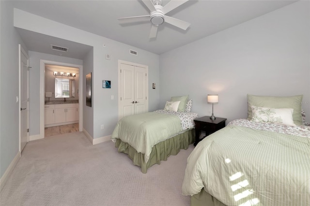 bedroom featuring a closet, baseboards, light colored carpet, and visible vents