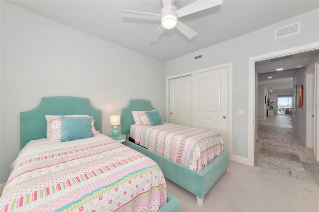carpeted bedroom featuring baseboards, ceiling fan, a closet, and visible vents