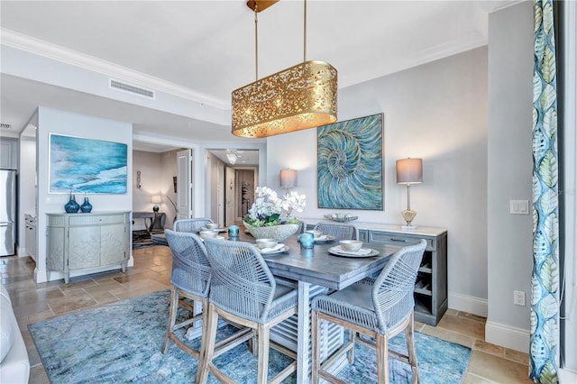 130 Riviera Dunes Way Unit 502, Palmetto, FL 34221 - dining space with crown molding, baseboards, stone tile flooring, and visible vents