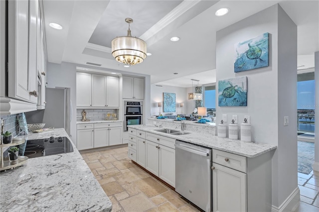 130 Riviera Dunes Way Unit 502, Palmetto, FL 34221 - kitchen featuring appliances with stainless steel finishes, a sink, recessed lighting, tasteful backsplash, and a tray ceiling