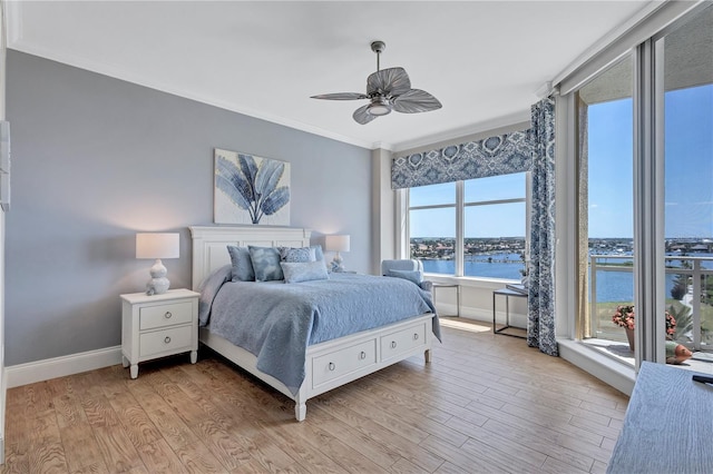 130 Riviera Dunes Way Unit 502, Palmetto, FL 34221 - bedroom featuring crown molding, light wood-style flooring, a ceiling fan, baseboards, and a water view
