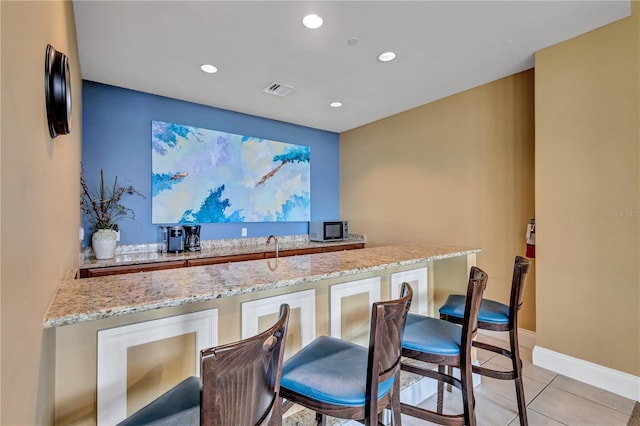 130 Riviera Dunes Way Unit 502, Palmetto, FL 34221 - bar with visible vents, light tile patterned floors, baseboards, stainless steel microwave, and recessed lighting