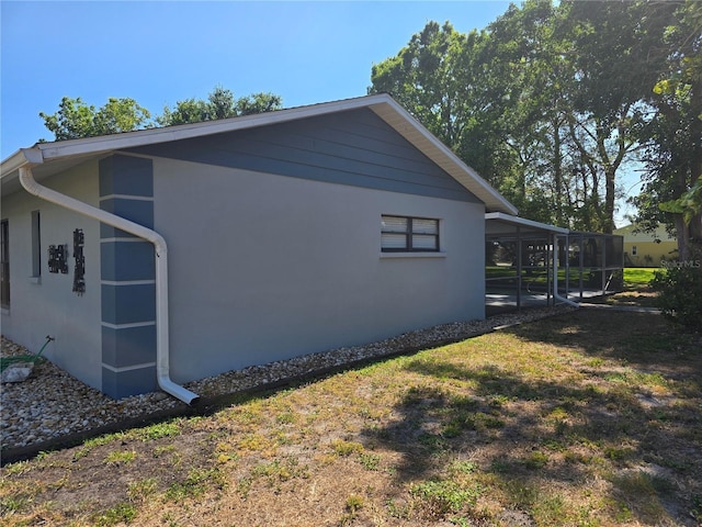 2204 34th St W, Bradenton, FL 34205 - view of side of property with a sunroom, stucco siding, and a lawn