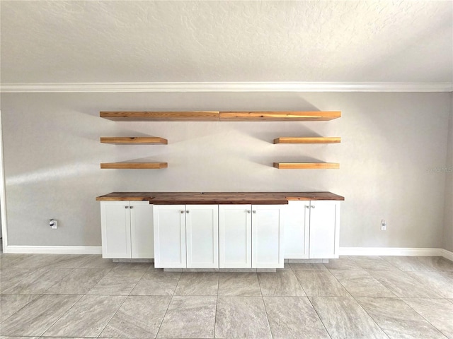 2204 34th St W, Bradenton, FL 34205 - bar featuring crown molding, baseboards, a textured ceiling, and light tile patterned flooring