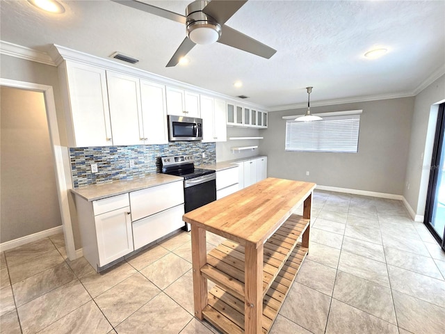 2204 34th St W, Bradenton, FL 34205 - kitchen with appliances with stainless steel finishes, crown molding, light countertops, tasteful backsplash, and white cabinetry