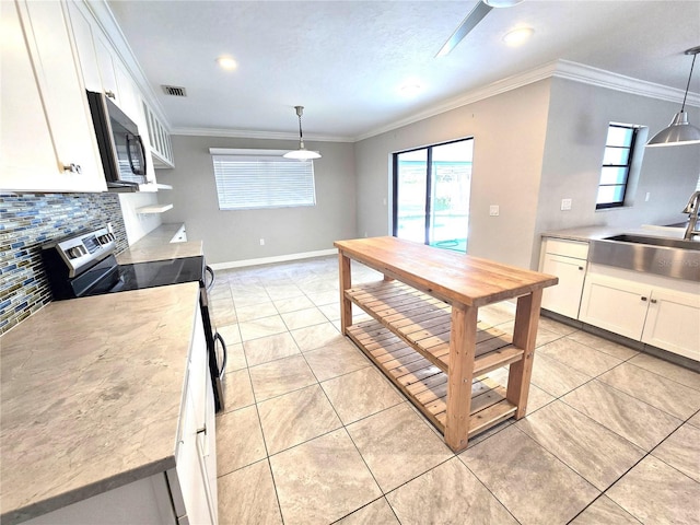 2204 34th St W, Bradenton, FL 34205 - kitchen with a sink, appliances with stainless steel finishes, white cabinets, tasteful backsplash, and plenty of natural light