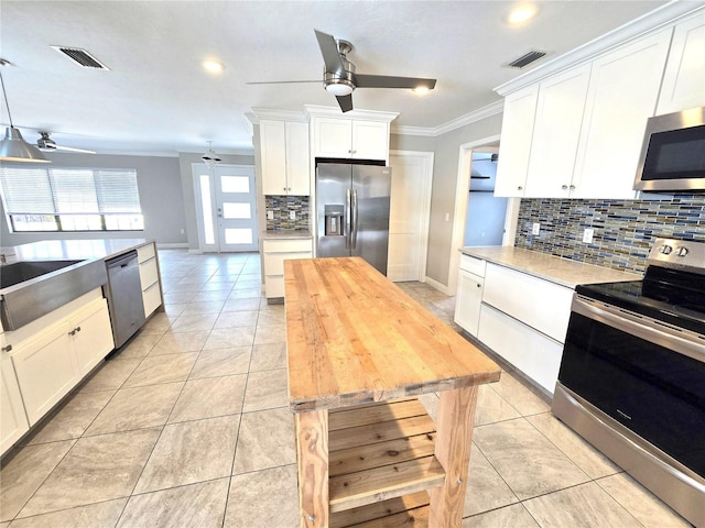 2204 34th St W, Bradenton, FL 34205 - kitchen featuring appliances with stainless steel finishes, ceiling fan, ornamental molding, decorative backsplash, and light tile patterned floors