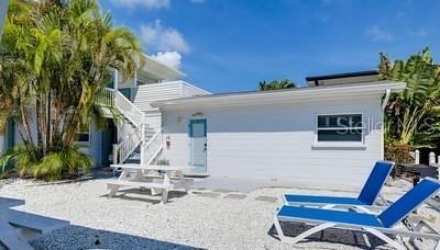 rear view of property featuring a patio area and stairs