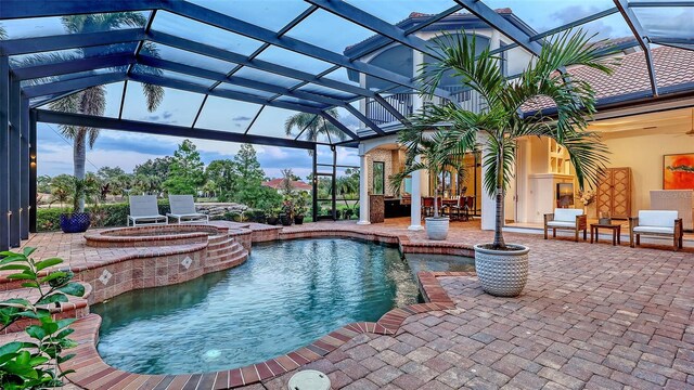 view of swimming pool with a lanai, a ceiling fan, a patio, and a pool with connected hot tub
