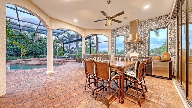 view of patio with area for grilling, ceiling fan, a lanai, outdoor dining area, and a hot tub