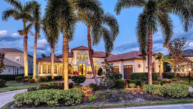 view of front of home featuring an attached garage, stucco siding, french doors, and a tile roof