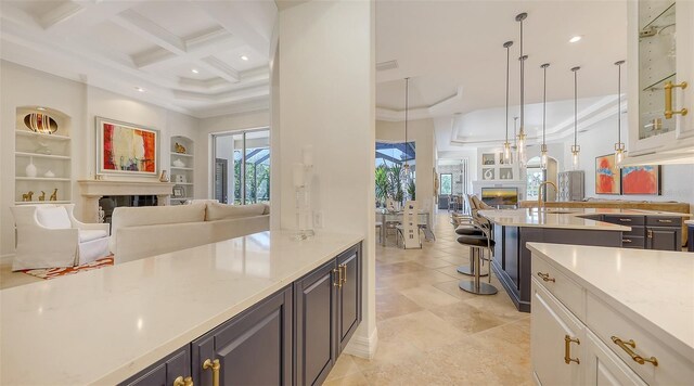 kitchen with open floor plan, coffered ceiling, a high ceiling, and a fireplace