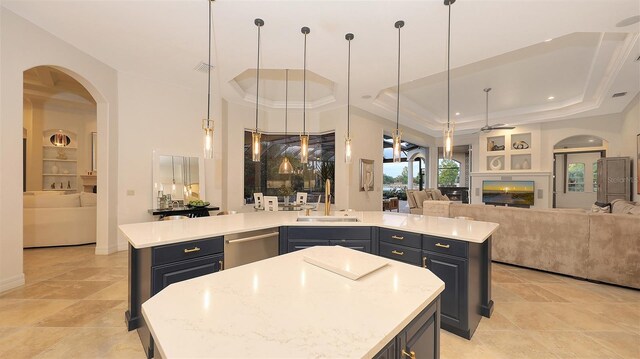 kitchen featuring a kitchen island, open floor plan, arched walkways, a sink, and dishwasher