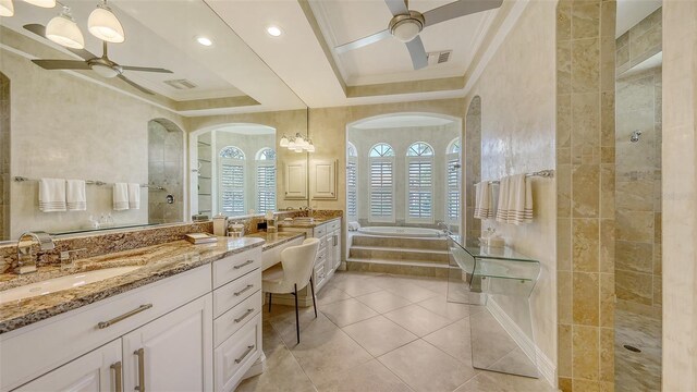 bathroom featuring ceiling fan, a garden tub, walk in shower, vanity, and ornamental molding