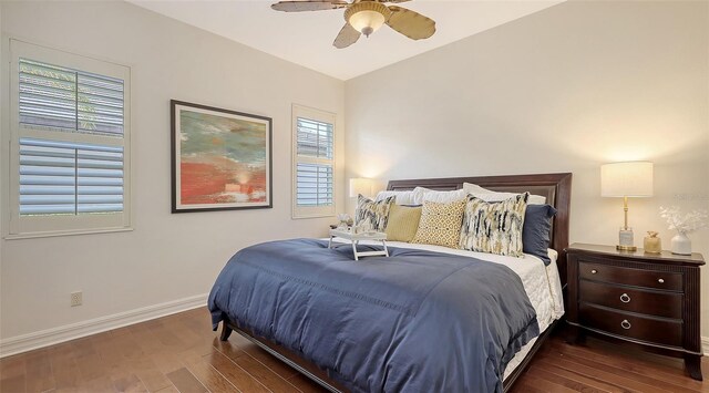 bedroom with baseboards, a ceiling fan, wood finished floors, and multiple windows