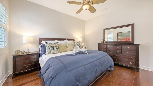 bedroom with baseboards, visible vents, ceiling fan, and dark wood-type flooring