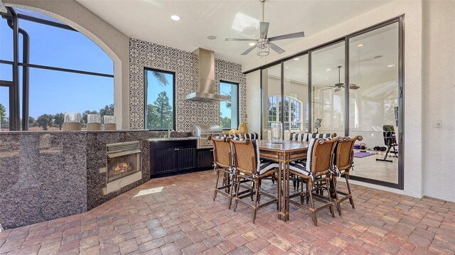 dining room featuring a glass covered fireplace and ceiling fan