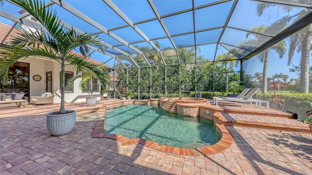 view of swimming pool with glass enclosure, a pool with connected hot tub, and a patio area