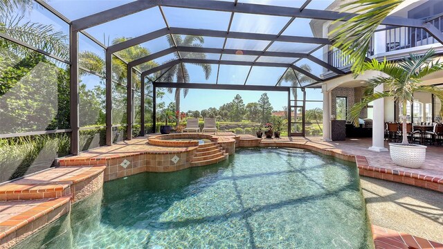 view of swimming pool featuring outdoor dining space, a patio, a pool with connected hot tub, and glass enclosure